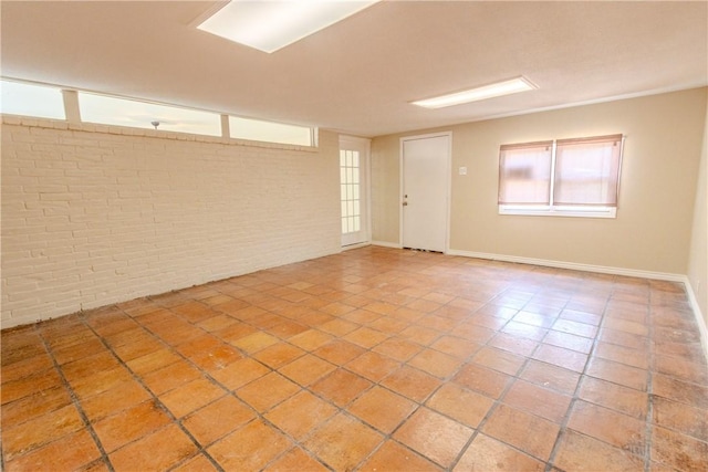 1553 Casa Grande Dr, Corpus Christi, TX 78411 - tiled empty room featuring brick wall and baseboards