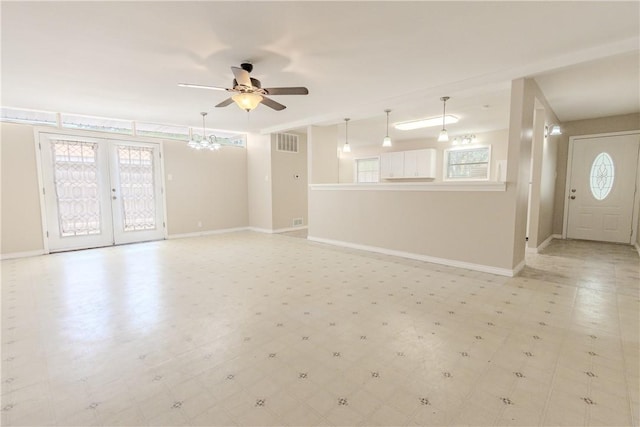 1553 Casa Grande Dr, Corpus Christi, TX 78411 - unfurnished living room with a ceiling fan, baseboards, french doors, and a chandelier