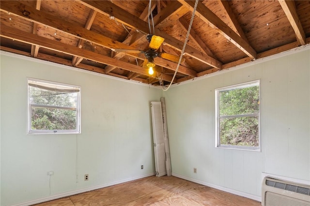 unfurnished room featuring light wood-style flooring, baseboards, heating unit, beamed ceiling, and wood ceiling