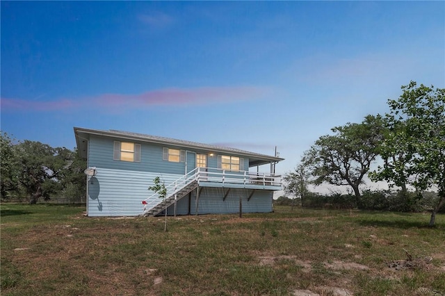 rear view of property with stairs and a yard