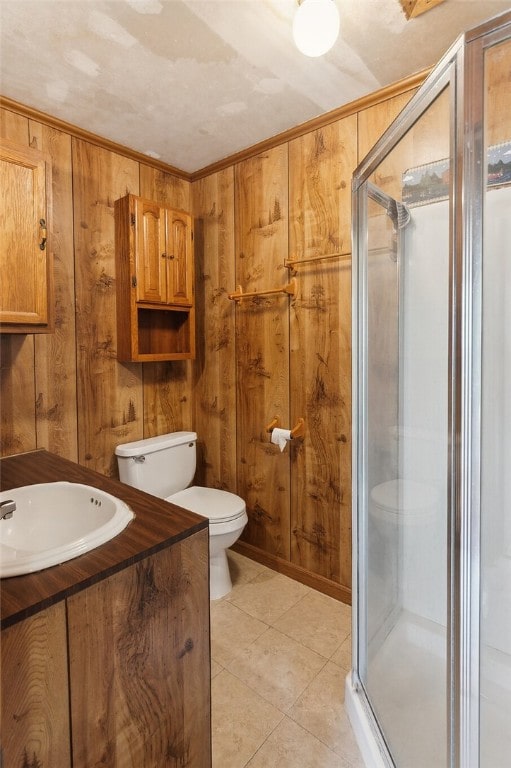 bathroom with vanity, wood walls, toilet, and a shower stall