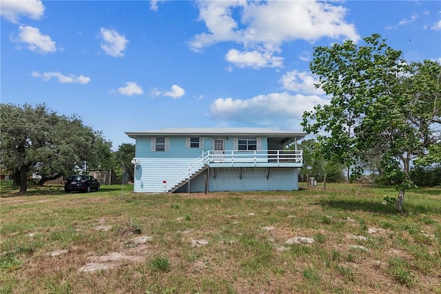 back of house featuring a yard and stairway
