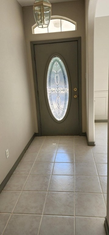 tiled foyer with a notable chandelier