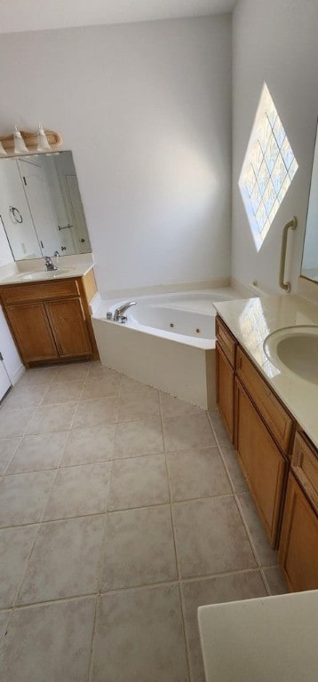 bathroom with tile patterned flooring, vanity, and a tub to relax in