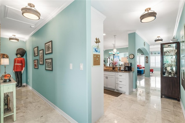 hallway featuring a chandelier, sink, and ornamental molding