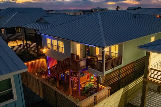 back house at dusk featuring a balcony