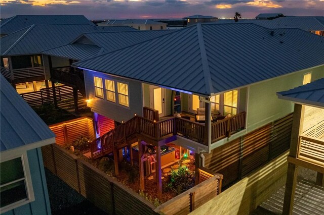 330 Paradise Pointe Dr, Port Aransas, TX 78373 - back of house at dusk featuring a standing seam roof, metal roof, and a fenced backyard