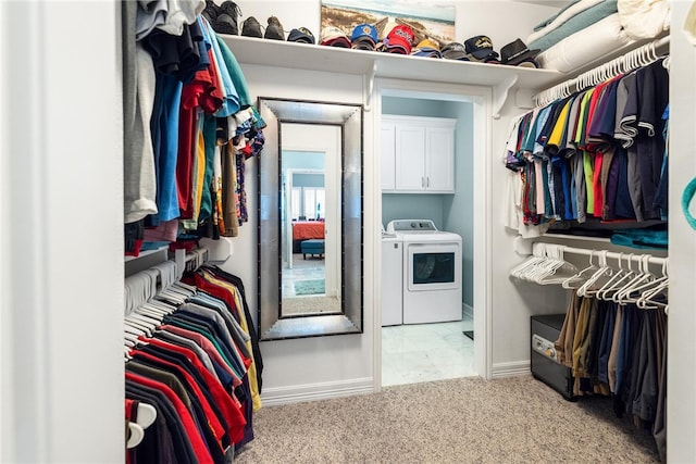 spacious closet featuring washer and clothes dryer and light carpet