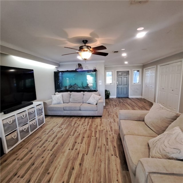 living room with hardwood / wood-style flooring, ceiling fan, and crown molding