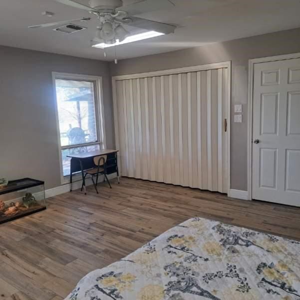 bedroom with light hardwood / wood-style flooring and ceiling fan