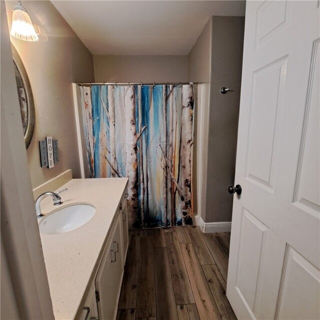 kitchen featuring backsplash, black appliances, white cabinets, sink, and light hardwood / wood-style flooring