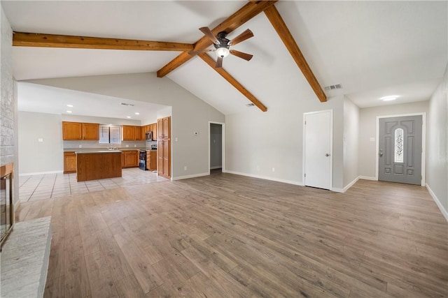 unfurnished living room featuring light wood-style floors, beam ceiling, visible vents, and baseboards