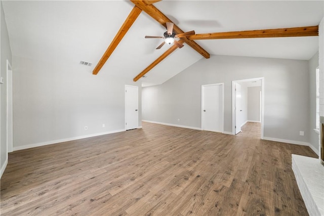 unfurnished living room with baseboards, visible vents, a ceiling fan, wood finished floors, and vaulted ceiling with beams