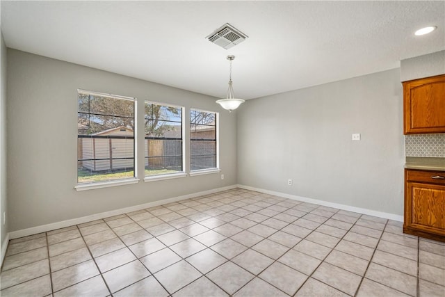 unfurnished dining area featuring baseboards and visible vents