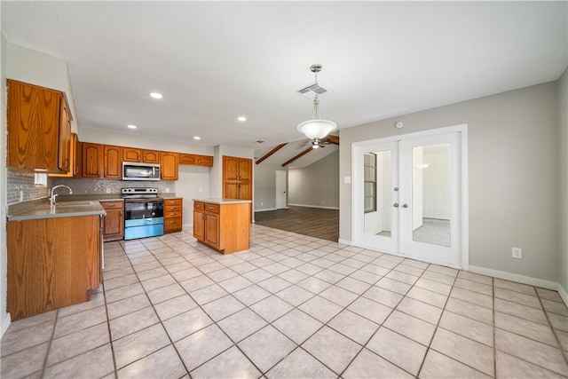 kitchen featuring stainless steel appliances, a sink, light countertops, backsplash, and brown cabinets