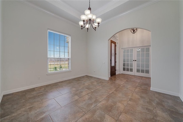 spare room with a notable chandelier, crown molding, a tray ceiling, and french doors