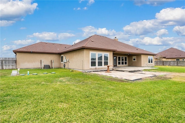 rear view of property featuring central AC unit, a patio area, and a lawn