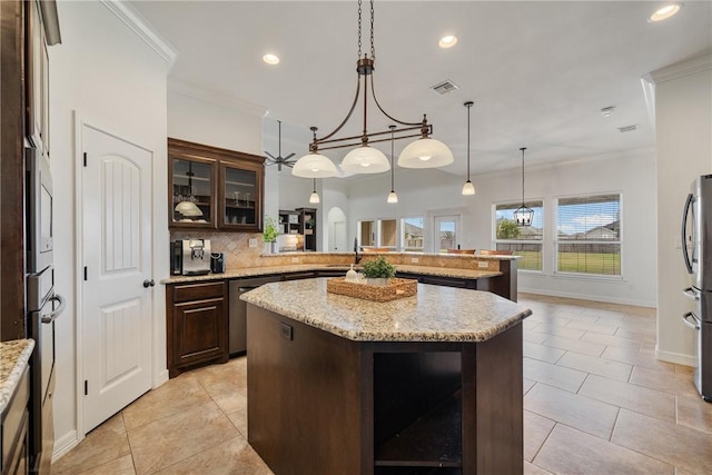 kitchen with a center island, decorative backsplash, dark brown cabinets, kitchen peninsula, and stainless steel appliances