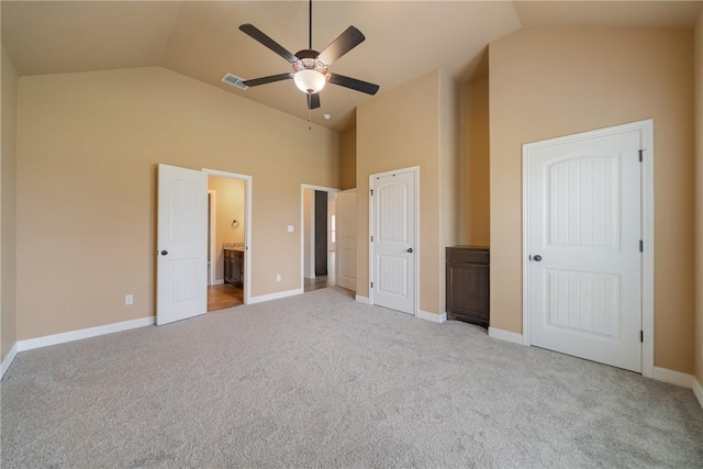 unfurnished bedroom with ceiling fan, light colored carpet, lofted ceiling, and ensuite bathroom