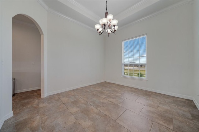 spare room with a chandelier, a tray ceiling, and crown molding