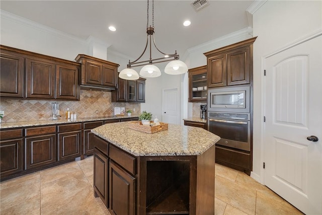 kitchen featuring ornamental molding, dark brown cabinets, stainless steel appliances, pendant lighting, and a center island