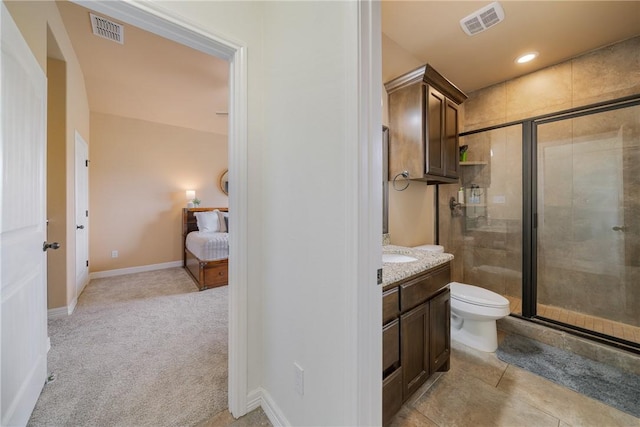 bathroom featuring tile patterned floors, vanity, toilet, and walk in shower