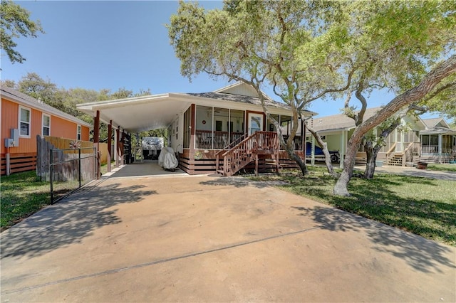 view of front of property featuring covered porch, a front yard, and a carport