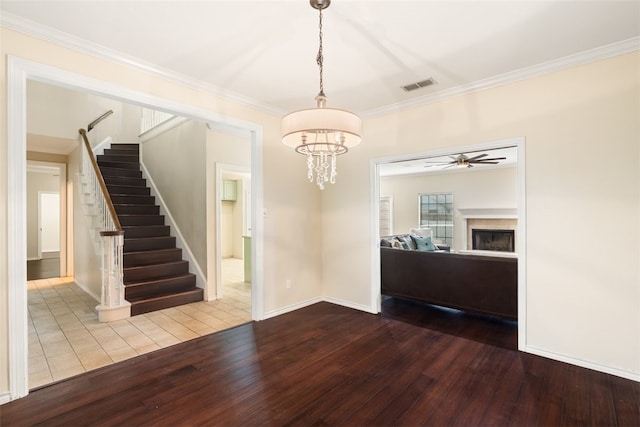 7030 Chiswick Dr, Corpus Christi, TX 78413 - unfurnished living room with hardwood / wood-style floors, stairway, crown molding, a fireplace, and a ceiling fan