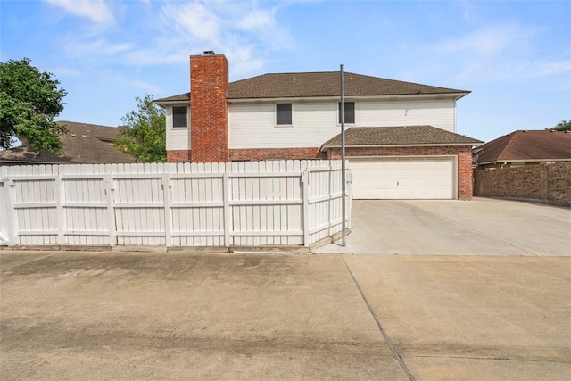 7030 Chiswick Dr, Corpus Christi, TX 78413 - rear view of house with brick siding, concrete driveway, a chimney, a garage, and a shingled roof