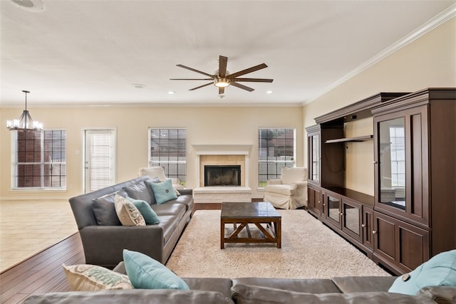 7030 Chiswick Dr, Corpus Christi, TX 78413 - living area with a chandelier, ceiling fan, a fireplace with raised hearth, hardwood / wood-style flooring, and crown molding