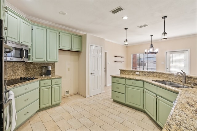7030 Chiswick Dr, Corpus Christi, TX 78413 - kitchen featuring stainless steel microwave, crown molding, backsplash, hanging light fixtures, and black electric cooktop