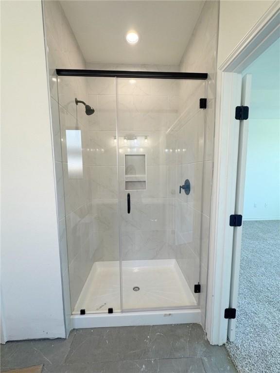 bathroom featuring a shower with door