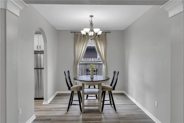 1119 Imperial St, Portland, TX 78374 - dining room with a chandelier, light wood-type flooring, arched walkways, and baseboards