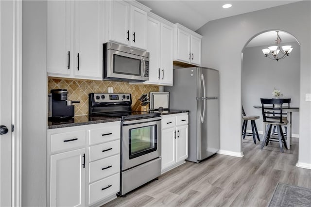 1119 Imperial St, Portland, TX 78374 - kitchen with appliances with stainless steel finishes, arched walkways, decorative backsplash, light wood finished floors, and a chandelier