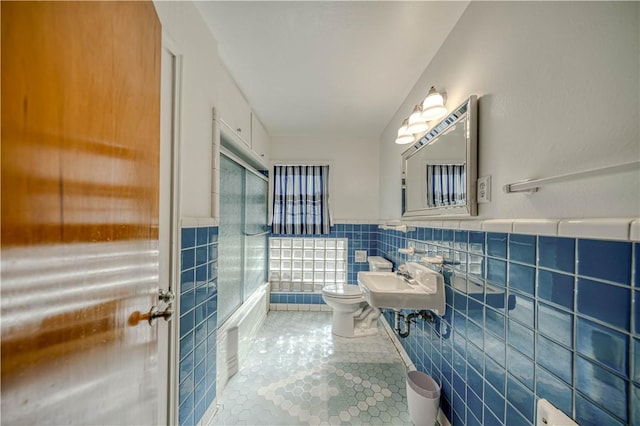 bathroom featuring sink, tile walls, tile patterned flooring, a shower, and toilet