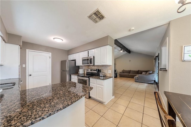 5929 Choctaw Dr, Corpus Christi, TX 78415 - kitchen with stainless steel appliances, white cabinets, ceiling fan, a peninsula, and light tile patterned flooring