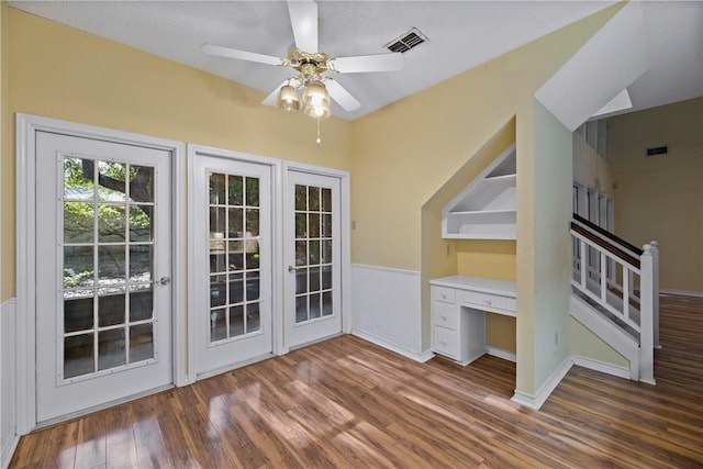 interior space with built in desk, dark hardwood / wood-style floors, and ceiling fan