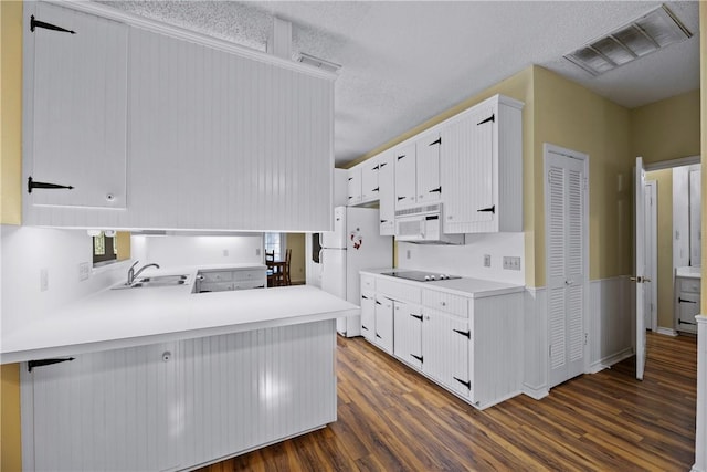 kitchen featuring sink, white appliances, dark hardwood / wood-style floors, white cabinets, and kitchen peninsula