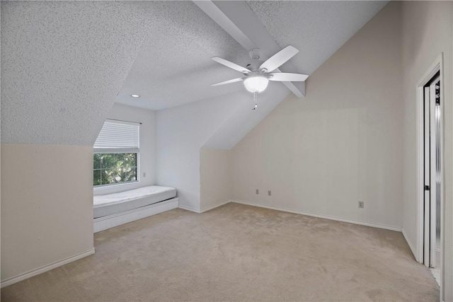 unfurnished bedroom featuring vaulted ceiling, ceiling fan, light carpet, and a textured ceiling