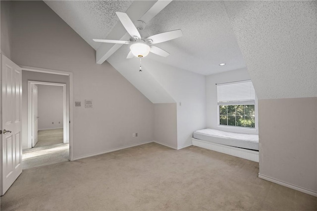 bonus room featuring ceiling fan, lofted ceiling, light colored carpet, and a textured ceiling