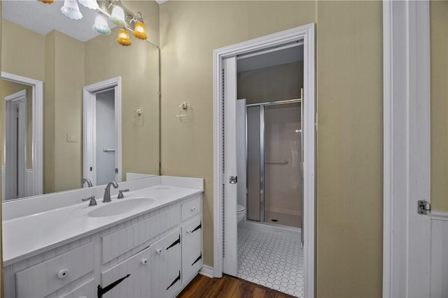 bathroom featuring vanity, hardwood / wood-style floors, an enclosed shower, and toilet