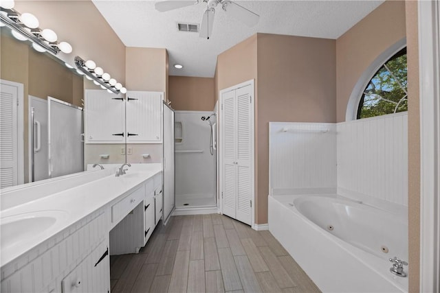 bathroom with vanity, hardwood / wood-style floors, a textured ceiling, and separate shower and tub