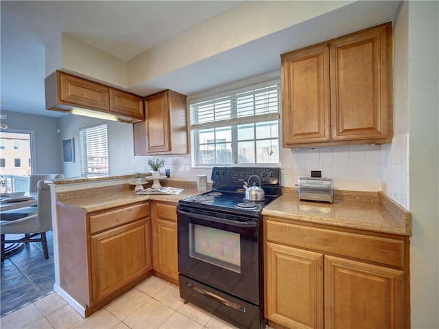 kitchen featuring a wealth of natural light, decorative backsplash, black electric range oven, and light tile patterned floors