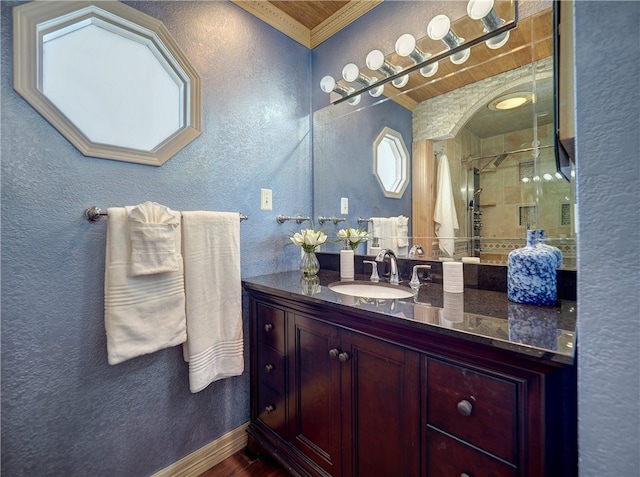 bathroom featuring vanity, a tile shower, and ornamental molding