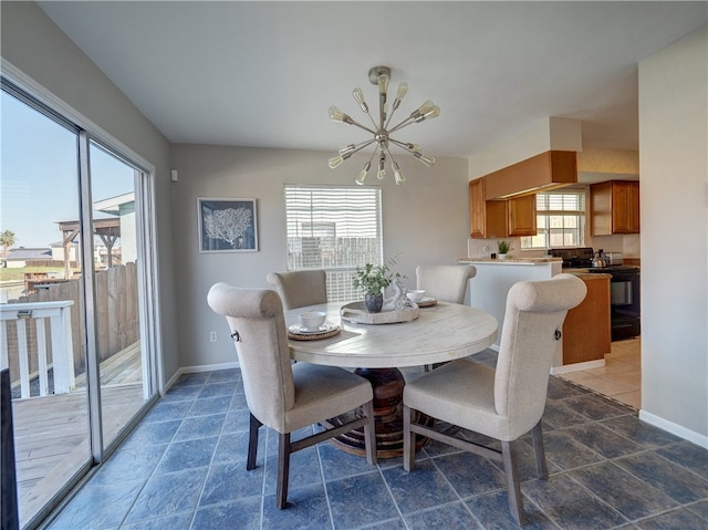 dining area with a chandelier and dark tile patterned flooring