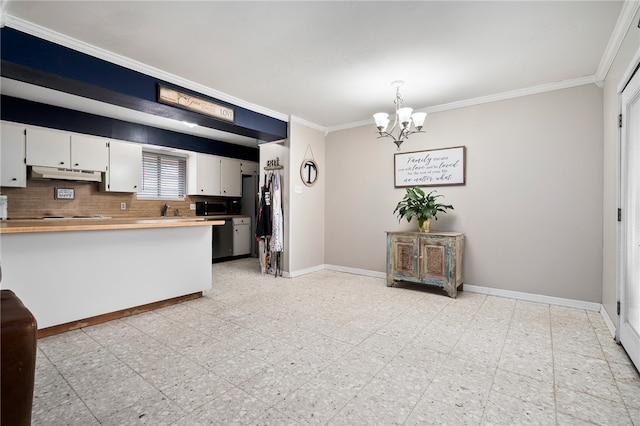 kitchen with tasteful backsplash, ornamental molding, hanging light fixtures, an inviting chandelier, and white cabinets