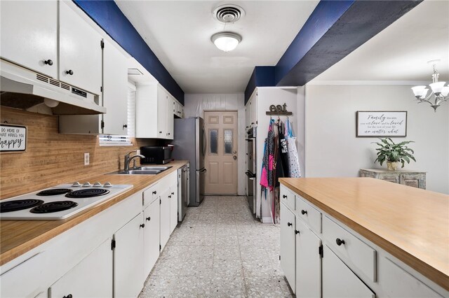 kitchen with an inviting chandelier, decorative backsplash, sink, white cabinetry, and appliances with stainless steel finishes