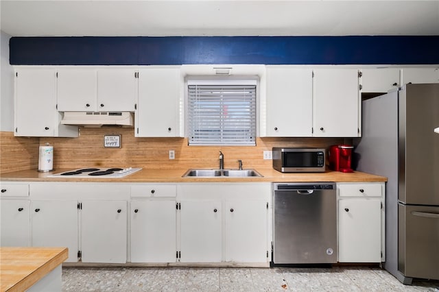 kitchen with stainless steel appliances, white cabinets, sink, and tasteful backsplash