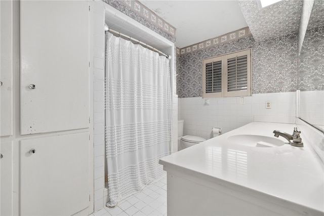 bathroom with tile walls, vanity, tile patterned flooring, curtained shower, and toilet