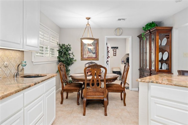 dining area featuring baseboards, visible vents, and light tile patterned floors